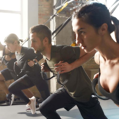 Eine Gruppe Personen beim Training mit TRX-Bändern im Fitnessstudio in Haslach