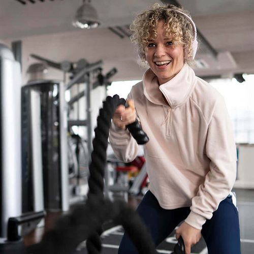 Frau beim aktiven Training mit Battle Ropes im Fitnessstudio in Haslach