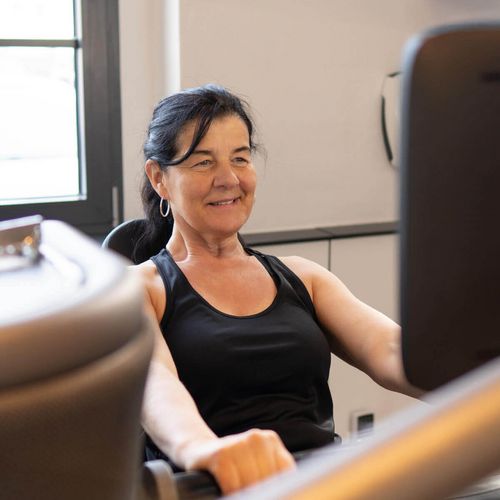 Ältere Dame beim Training mit milon Kraftzirkel im Fitnessstudio in Haslach