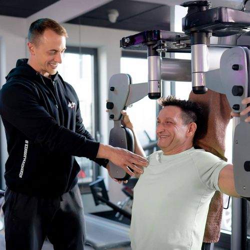 Mann mit Trainer beim Krafttraining im Fitnessstudio in Haslach